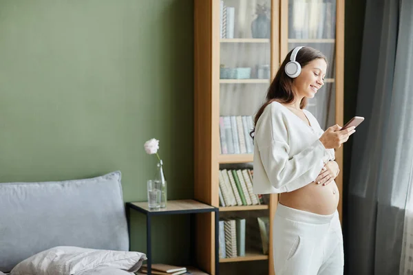 Žena používající hudební terapii pro těhotenství — Stock fotografie