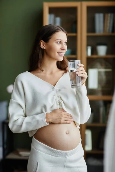 Kobieta w ciąży wody pitnej w domu — Zdjęcie stockowe