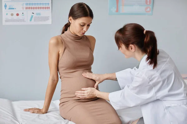 Lékař zkoumá těhotná žena — Stock fotografie