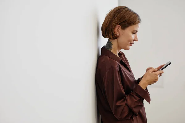 Tattooed Woman using Smartphone in Office Minimal — Stock Photo, Image