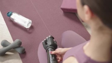 Protez kollu genç bir kadının evde yoga yaparken çekilmiş yavaş çekimleri.