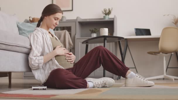 Dźgnięcie Powolne Ujęcie Młodej Zrelaksowanej Białej Kobiety Ciąży Siedzącej Podłodze — Wideo stockowe
