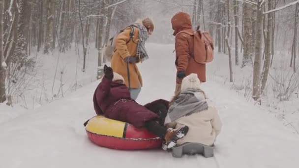 Повільний Знімок Двох Веселих Молодих Різноманітних Жінок Сидять Снігових Трубках — стокове відео
