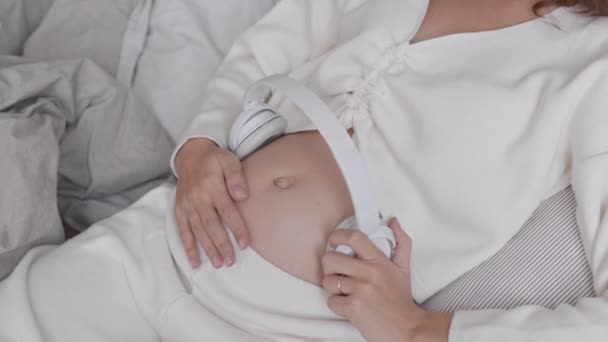 Średnie Zbliżenie Spowolnieniem Młodej Białej Kobiety Ciąży Łóżku Trzymającej Słuchawki — Wideo stockowe