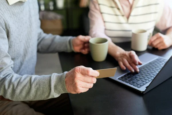 Uomo anziano in possesso di carta di credito durante lo shopping online — Foto Stock