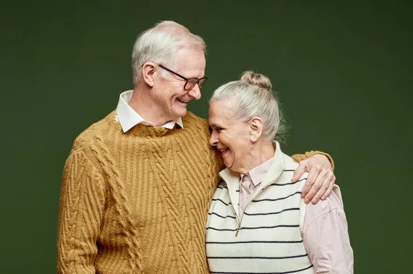 Riendo pareja mayor en ropa casual de pie sobre fondo verde oscuro —  Fotos de Stock