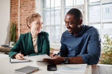 Belgeleri tartışan iki genç ekonomist ya da yönetici