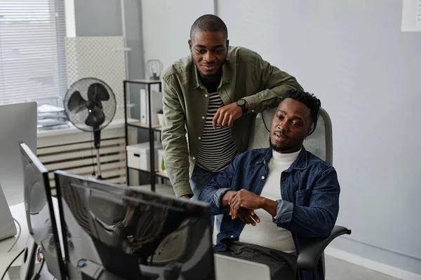 Dois jovens colegas discutindo informações de trabalho na tela do computador — Fotografia de Stock