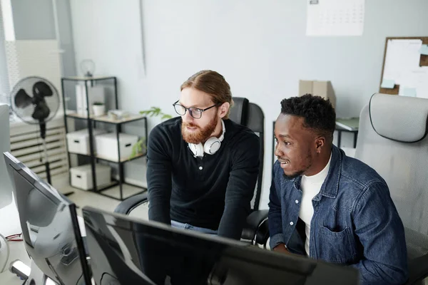 Dos jóvenes programadores de diversidad intercultural mirando a la pantalla de computación — Foto de Stock