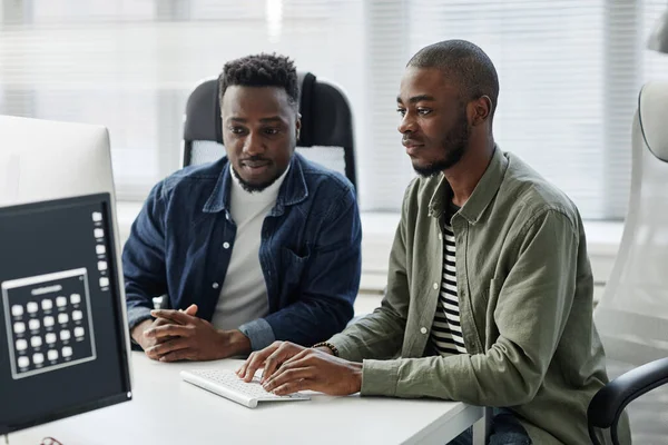 Dois jovens programadores contemporâneos da diversidade introduzindo dados no computador — Fotografia de Stock