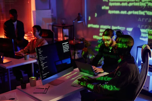 Groupe de jeunes collaborateurs interculturels assis près des bureaux devant les ordinateurs — Photo