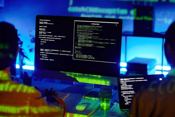 Компьютерный экран с декодированными данными и двумя молодыми современными программистами — стоковое фото