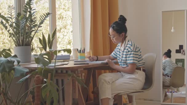 Asyalı Genç Bir Kızın Ödevini Yaparken Odasında Masasında Akıllı Telefon — Stok video