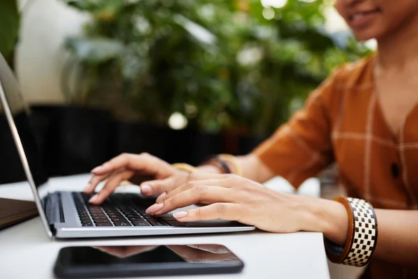 Mãos de mulher biracial jovem digitando no teclado do laptop — Fotografia de Stock