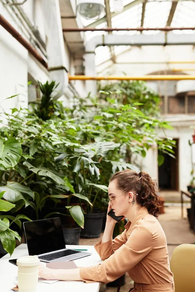 若い女性花屋が携帯電話で新しい植物の注文をする — ストック写真