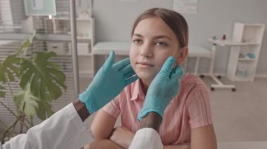 13 yaşındaki beyaz bir kızın klinikteki randevusu sırasında lenf düğümlerini erkek pediatrist tarafından muayene edilirken elde taşınan POV yavaş çekimi.