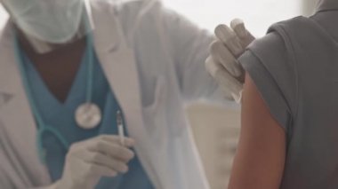 Afro-Amerikan doktorların, tanınmayan küçük bir kıza Covid-19 aşısı yaparken yavaş yavaş çekimleri.