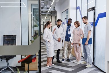 Genç başhekim tartışma sırasında klinikçilerden birini işaret ediyor.