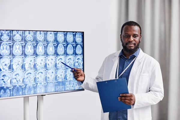 Joven oficial médico afroamericano confiado apuntando al escáner cerebral —  Fotos de Stock
