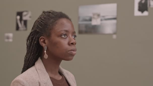 在当代艺术画廊 年轻的非洲裔美国女人看着墙上的图片和照片时 倾斜的慢镜头 — 图库视频影像