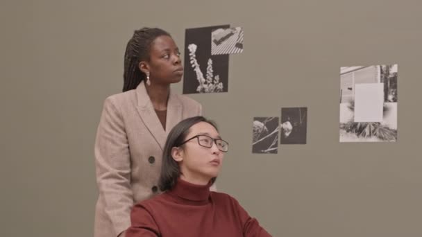 現代美術ギャラリーを訪れながら 車椅子の笑顔でカメラを構える障害のあるアジア系の若者とアフリカ系アメリカ人の女性の中低速肖像画 — ストック動画