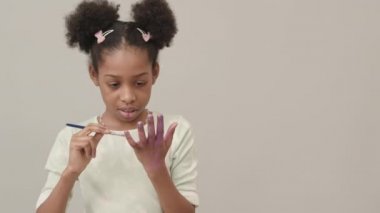 Güzel Afro-Amerikan bir kızın belini kaldır mor renkli avuç içini göster ve kameraya gülümse.