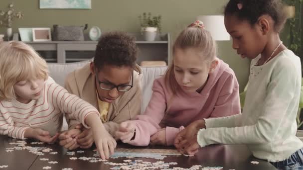 4个多民族小学生在家中一起解决拼图游戏的动作缓慢 — 图库视频影像