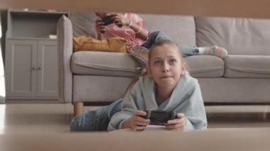 joystick 'li Kafkasyalı kız, boş zamanlarında evde yerde video oyunları oynuyor.