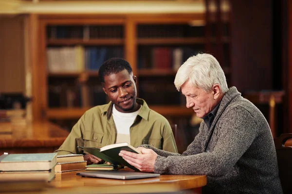 Dois homens lendo na biblioteca — Fotografia de Stock