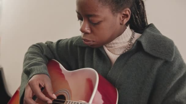音楽学校でアコースティックギターを演奏する若いアフリカ系アメリカ人女性の遅い閉鎖 — ストック動画