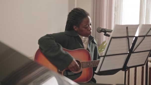Lentitud Media Joven Afroamericana Tocando Guitarra Cantando Micrófono Sentado Solo — Vídeo de stock