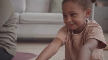Gen Dolly yavaş Afrikalı-Amerikalı küçük bir kız evde yoga minderi üzerinde esneme egzersizleri yapıyor.