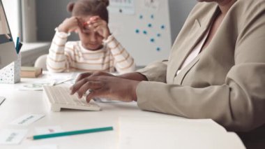 5 yaşındaki Afrika kökenli Amerikalı kız konuşma terapisi egzersizleri yapıyor. Sınıfta kadın öğretmenle birlikte bilgisayar üzerinde çalışıyor ve ona yardım ediyor.