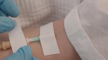 Hastane yatağında yatan hastanın koluna yavaş yavaş serum takılı.