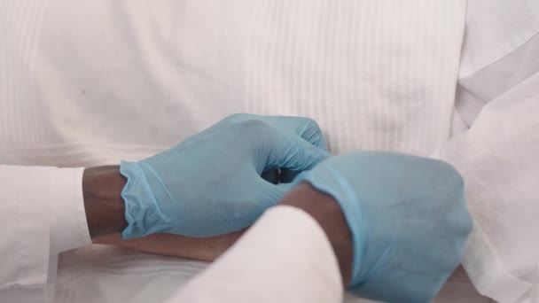 Медленное Приближение Перчаточных Рук Доктора Прикрепляющего Капельницу Руке Пациента — стоковое видео