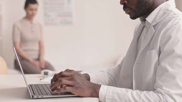 Modern Klinikteki Kontrol Sırasında Tıbbi Kanepede Oturan Bayanla Konuşurken Laptopta — Stok video