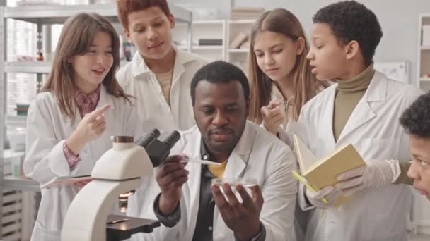 Mediana Inyección Estudiantes Multiétnicos Secundaria Profesor Afroamericano Batas Laboratorio Mirando — Vídeo de stock