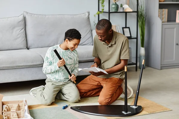 Hombre negro ensamblando muebles con hija —  Fotos de Stock