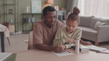 Afrika kökenli Amerikalı bir adam ve güzel küçük kızının rahat bir oturma odasında masa başı çekimleri, tecrit sırasında evde kalmaları.
