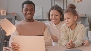 Orta yaşlı, mutlu, ırklar arası bir çift ve 8 yaşındaki tatlı kızları dizüstü bilgisayarlarında komik videolar izliyorlar. Kilitleme sırasında evde birlikte kalıyorlar.