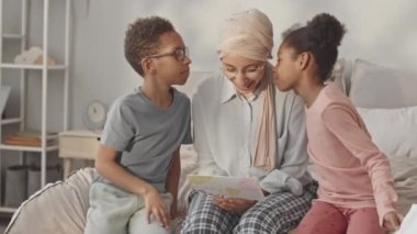 Anneler Günü 'nde annelerini tebrik eden, el yapımı kartpostallar atan ve iki yanağından öpen iki tatlı Afro-Amerikan kardeşin orta yavaşlığı.