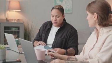 İç işlerinde birlikte çalışırken ırklar arası iş belgelerini tartışan iki kadın meslektaşın belini bük.