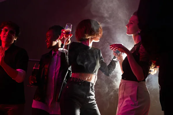 两名年轻女子在人群中跳舞的背光肖像 同时在烟熏熏天的俱乐部聚会 复制空间 — 图库照片