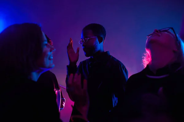 在由霓虹灯点燃的烟雾弥漫的俱乐部里 在人群中跳舞的黑人年轻人的背光肖像 复制空间 — 图库照片