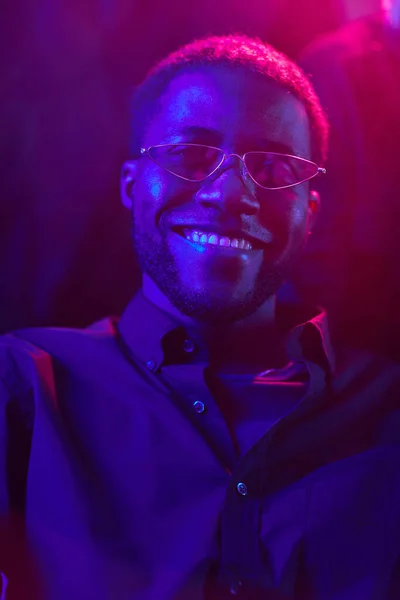 Κάθετη Πορτρέτο Του Νεαρού Αφροαμερικανού Άνδρα Χαμογελώντας Στο Κλαμπ Φωτίζεται — Φωτογραφία Αρχείου
