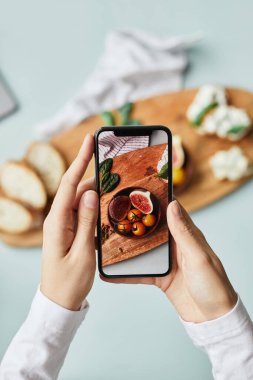 Stüdyoda akıllı telefon kullanan genç bir kadının estetik fotoğraf çekimini en aza indirmek.