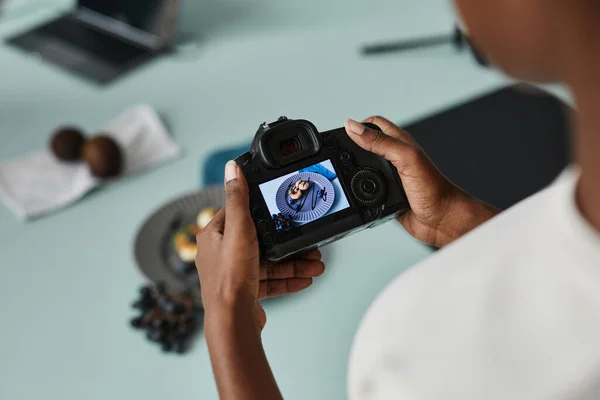 Close up of unrecognizable food photographer holding camera with image on screen, copy space