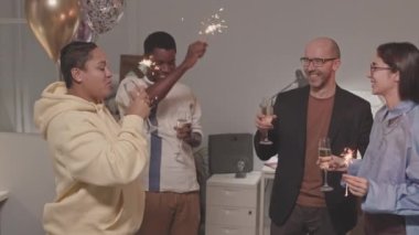 Şampanya kadehleri ve ellerinde maytaplar olan neşeli çoklu etnik meslektaşların orta derecede yavaşlaması ya da geceleri başarılı bir projeyi kutlamaları.