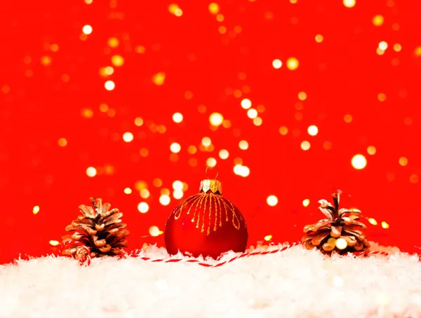 Bugiganga de Natal vermelho na textura da neve. Cartão de Natal com lugar para o seu texto. — Fotografia de Stock