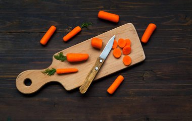 Ahşap zemin üzerinde tam ve küçük havuç dilimleri. Yaratıcı kopyalama alanı